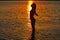Girl silhouette at beach sunset open arms