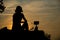 Girl silhouette cooking coffee on camping stove at sunrise light, outdoor picnic camping