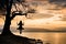 A girl in silhouette enjoying the sunset in swing