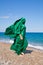 Girl silhouette in green tissue on the sea beach