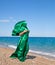 Girl silhouette in green tissue on the sea beach