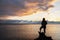 A girl silhouette  stands on the shore of the lake looks at beautiful sunset.