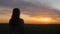 Girl silhouette at sunset walking in field of wheat, young woman in solitude on nature, concept lifestyle, meditating