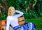 Girl sit bench relaxing in shadow, green nature background. Why you deserve break. Ways to give yourself break and enjoy