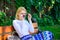 Girl sit bench relaxing in shadow, green nature background. Woman blonde with sunglasses dream about vacation, take