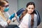 Girl sit in chair in dentist`s room. Doctor look at her. Scared girl. She refuse treatment.