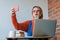 Girl sititng at table with computer and do a selfie