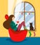 A girl sits in a chair by the winter window decorated with festoons and reads a book with a mug of hot drink, a cat sits on the wi