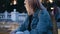 The girl sits on the edge of a beautiful glowing fountain.