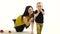 Girl sits on the floor, next to the vegetables lie, she tries to hold the baby. White background. Slow motion