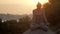 Girl sits in padmasana on round rock at sunrise slow motion