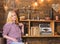 Girl sits and relaxing in house of gamekeeper. Girl in casual outfit sits in wooden vintage interior. Lady blonde on