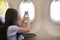 The girl sits in salon the plane on passenger sitting.