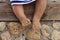 Girl sits weighing her childrens legs sand