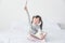 Girl sitting on bed and smile while holding pencil