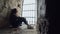 Girl is sitting behind bars at the window in a stone fortress. Focus on the wall, the girl is blurred