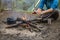 Girl sitting while camping near the fire heated and drink hot tea