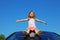 Girl sitting on car roof with open hands