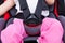 Girl sitting at carseat and fasten seat belt