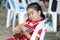 Girl Sitting chair with a cheerful serious playing ukulele