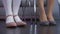 Girl sitting on chair near mother, stomping pink shoes playfully, waiting queue