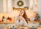 Girl sitting in Christmas decorated kitchen and thinking about future plans for coming year