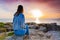 A girl sitting on a cliff watching Atlantic Ocean