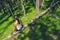 Girl sitting on the fallen tree deep in woods on sunny spring day