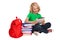 Girl sitting on the floor near books and bag holding tablet