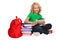 Girl sitting on the floor near books and bag holding tablet