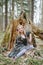 Girl sitting in the forest near crashed tree