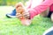 Girl sitting on green grass in the park. Foot pain from the wrong exercise .Symptoms of peripheral neuropathy. Most symptoms are