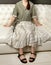 Girl sitting with her palms on a white leather sofa