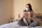 Girl sitting at home in quarantine, masked and with pills, treatment of coronavirus at home, self-isolation
