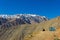 Girl sitting by igloo camping tent contemplating Andes snowy mountain range