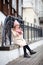 Girl sitting leaning against forged cast-iron fence of a building