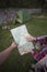 Girl sitting near a campfire at the campsite looking at map and drinking coffee.