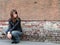 Girl sitting near grunge wall