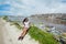 Girl sitting near the river filled with plastic bottles at garbage dump