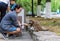 Girl sitting in the park and feeding raccoon
