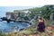 Girl sitting at a picturesque rocky coastline