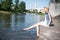 Girl sitting at the pier and hanging bare feet