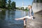 Girl sitting at the pier and hanging bare feet