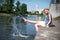 Girl sitting at the pier and hanging bare feet