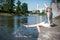 Girl sitting at the pier and hanging bare feet