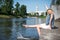 Girl sitting at the pier and hanging bare feet