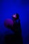 Girl sitting profile dark under UV light with ball