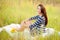 Girl sitting on a quilt in a field with sunflowers