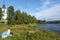 Girl is sitting in on returned bark and looking at Storan-Osterdalalven lake, the Protestant church of Idre village is at right