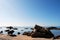 Girl sitting on a rock on a sandy beach. Tropical island.